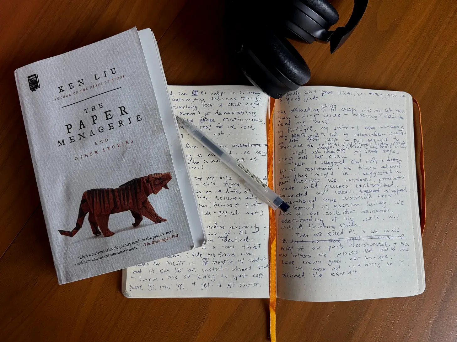 Ken Liu’s The Paper Menagerie beside a handwritten notebook, pen, and headphones.